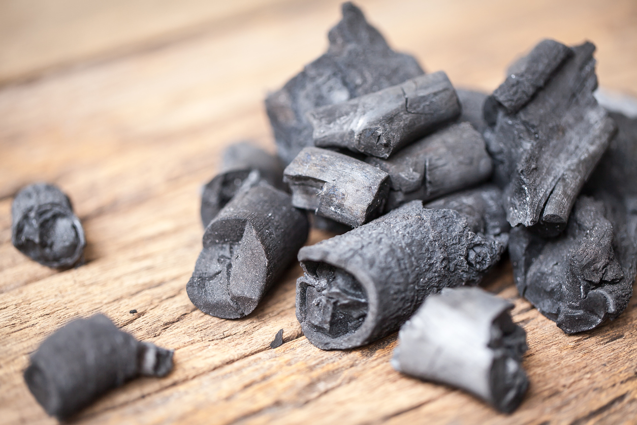 pile of charcoal pieces on wooden surface