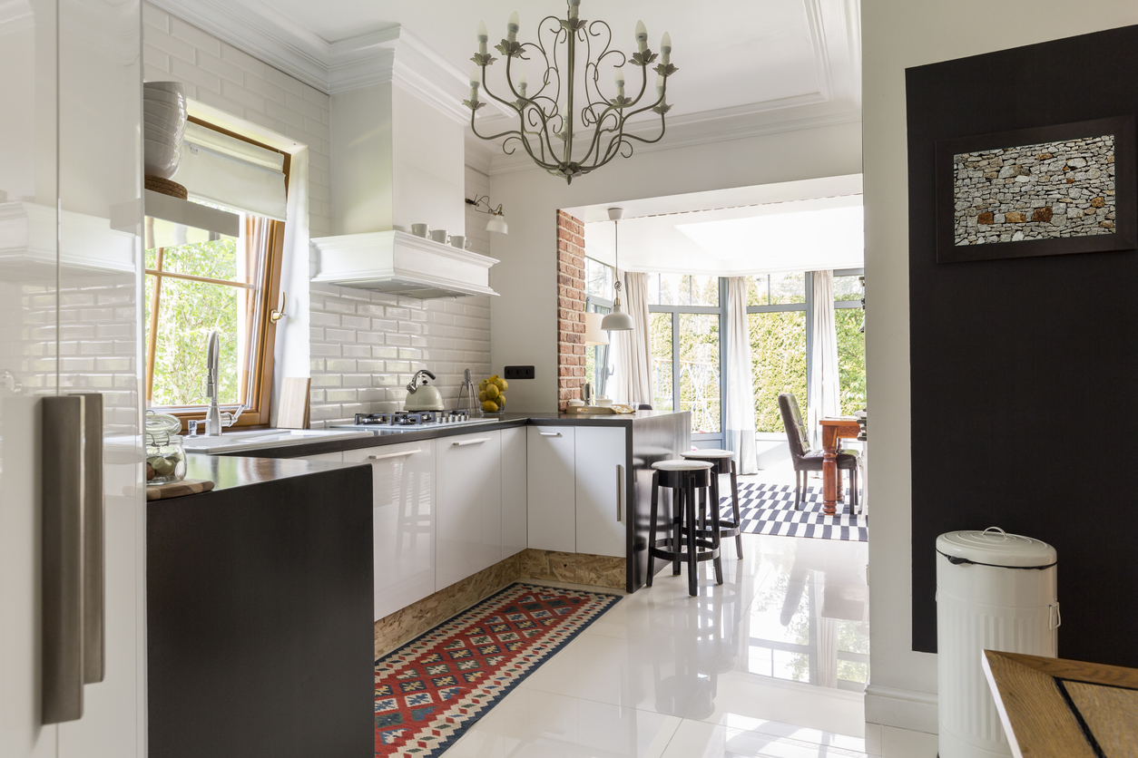 white-and-black-kitchen-with-a-red-patterned-runner-rug-in-front-of-the-sink-and-stove