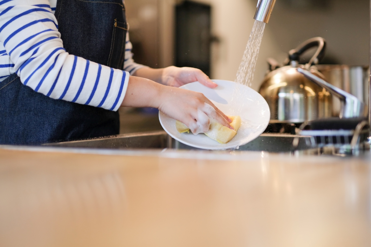 Person washing dishes at the kitchen sink.