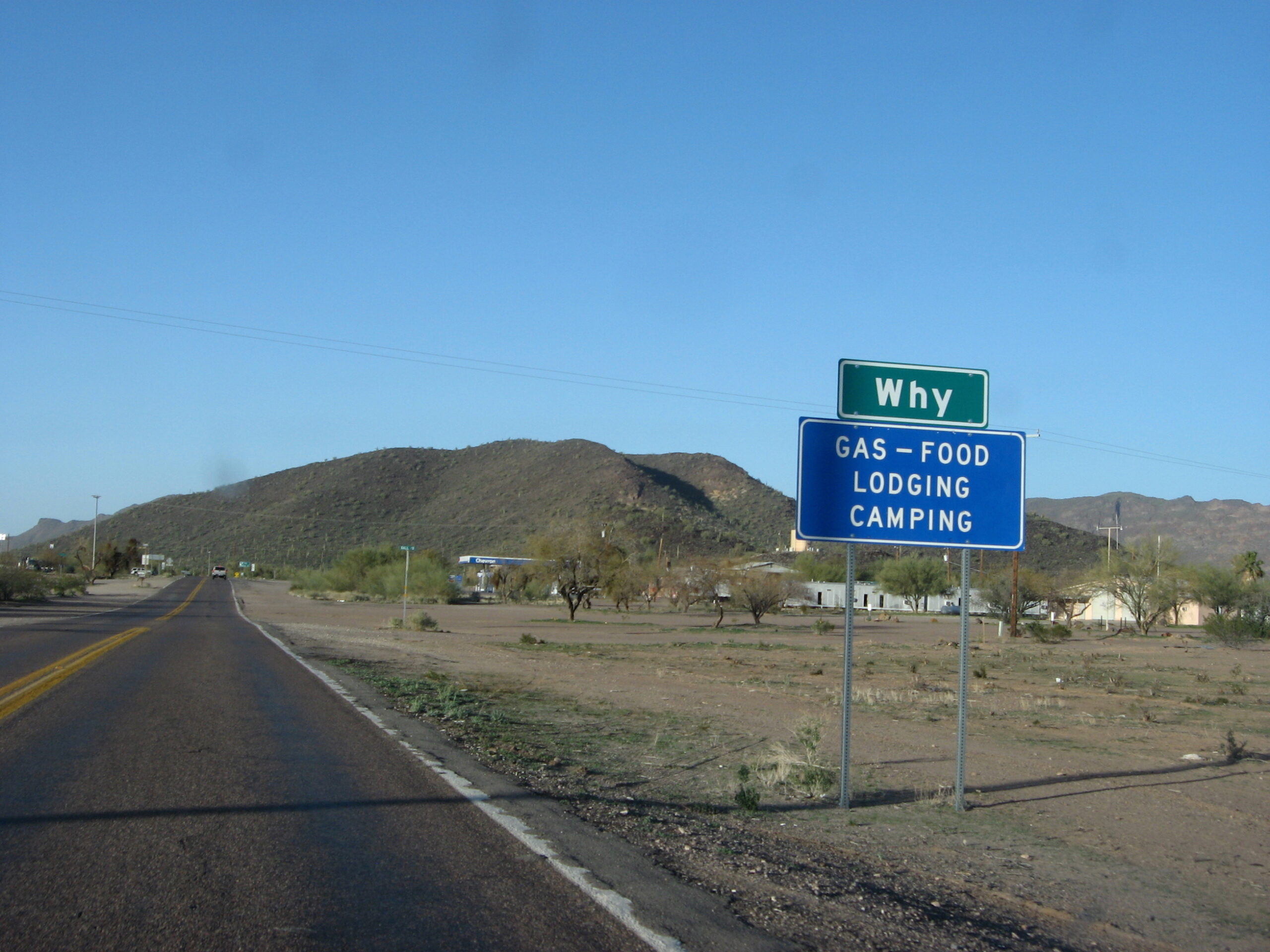 road sign for why arizona against desert road landscape