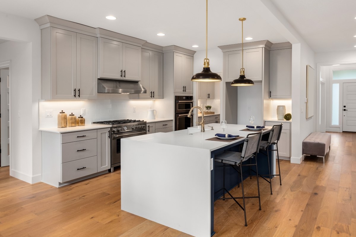 Large modern kitchen with gray cabinets and cove molding.