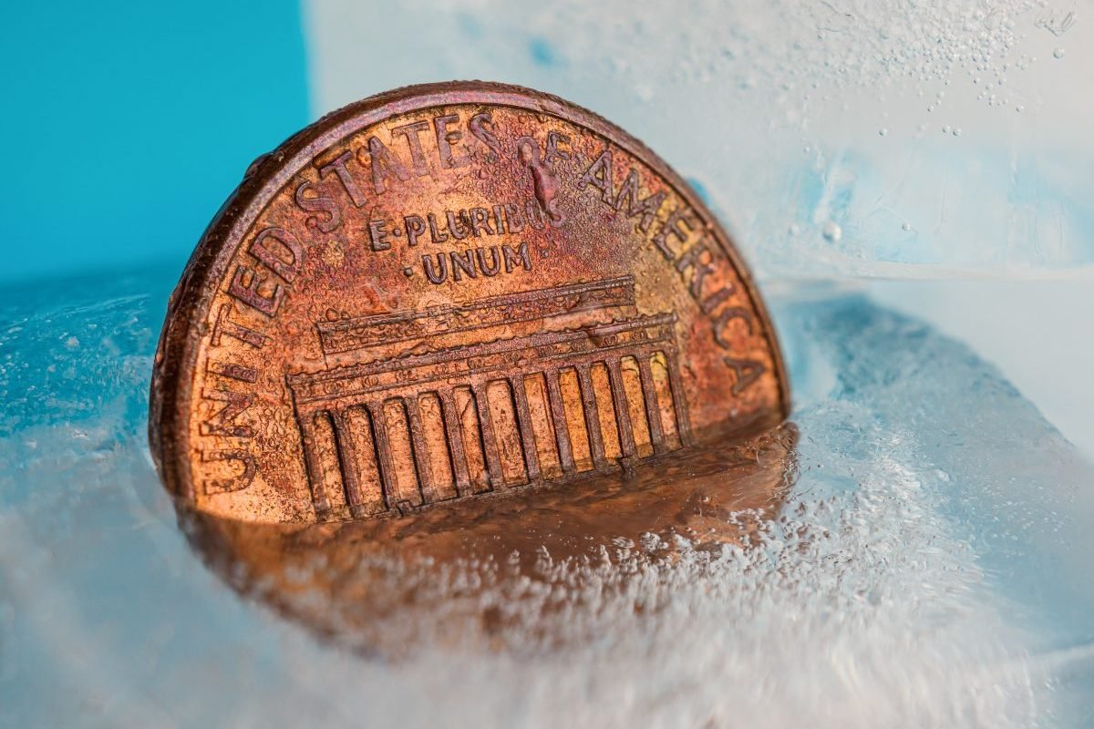 US one cent coin in ice to show a drop in temperature has occurred.