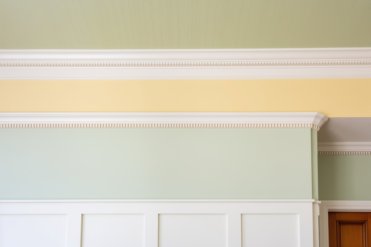 A view of dentil molding with yellow and light green walls.