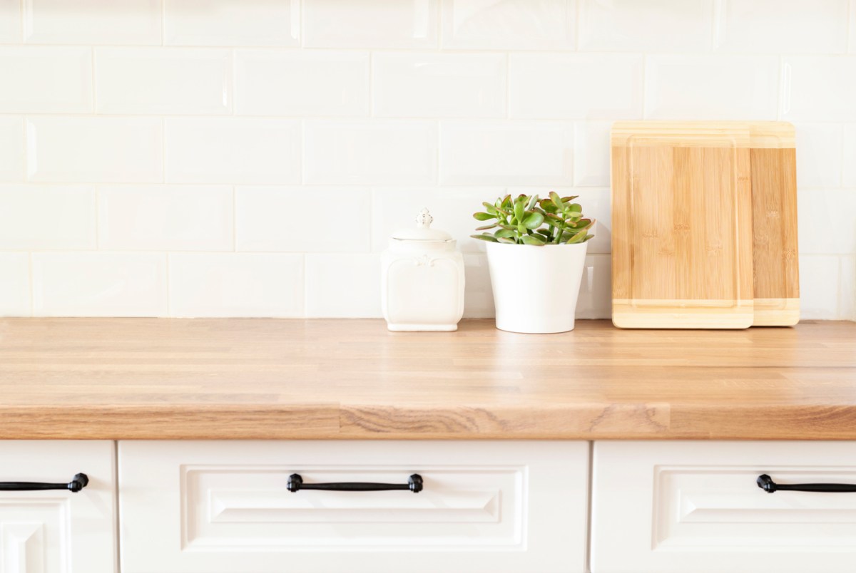Maple butcher block countertop in a bright kitchen with white cabinets