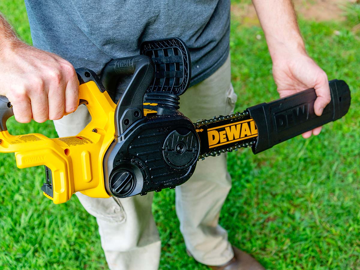 A person removing the bar cover on the DeWalt 20V chainsaw