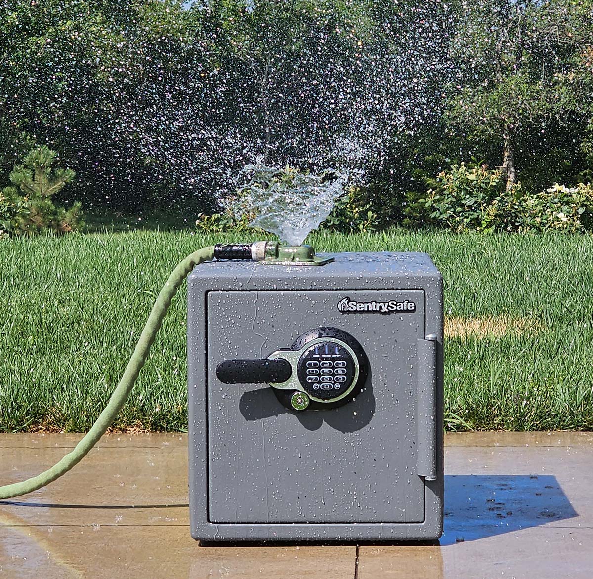 The SentrySafe home safe undergoing a water-resistance test with a sprinkler on it