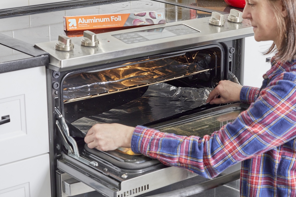 Woman tucks aluminum foil 