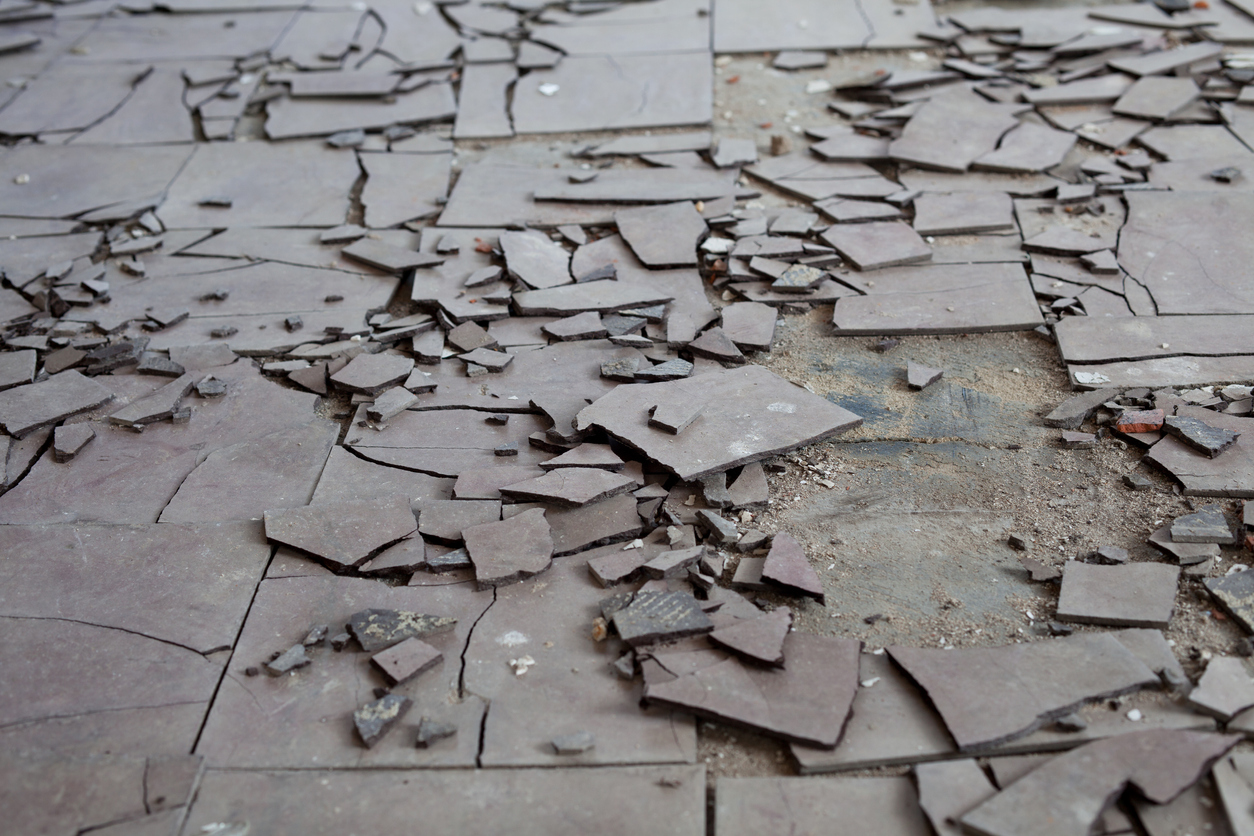 Broken gray asbestos floor tiles