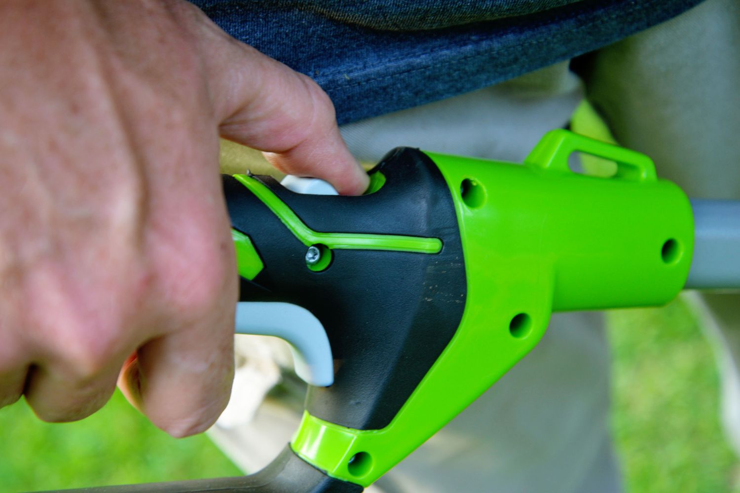 A close-up of the power and safety switches on the Greenworks 40V cordless pole saw