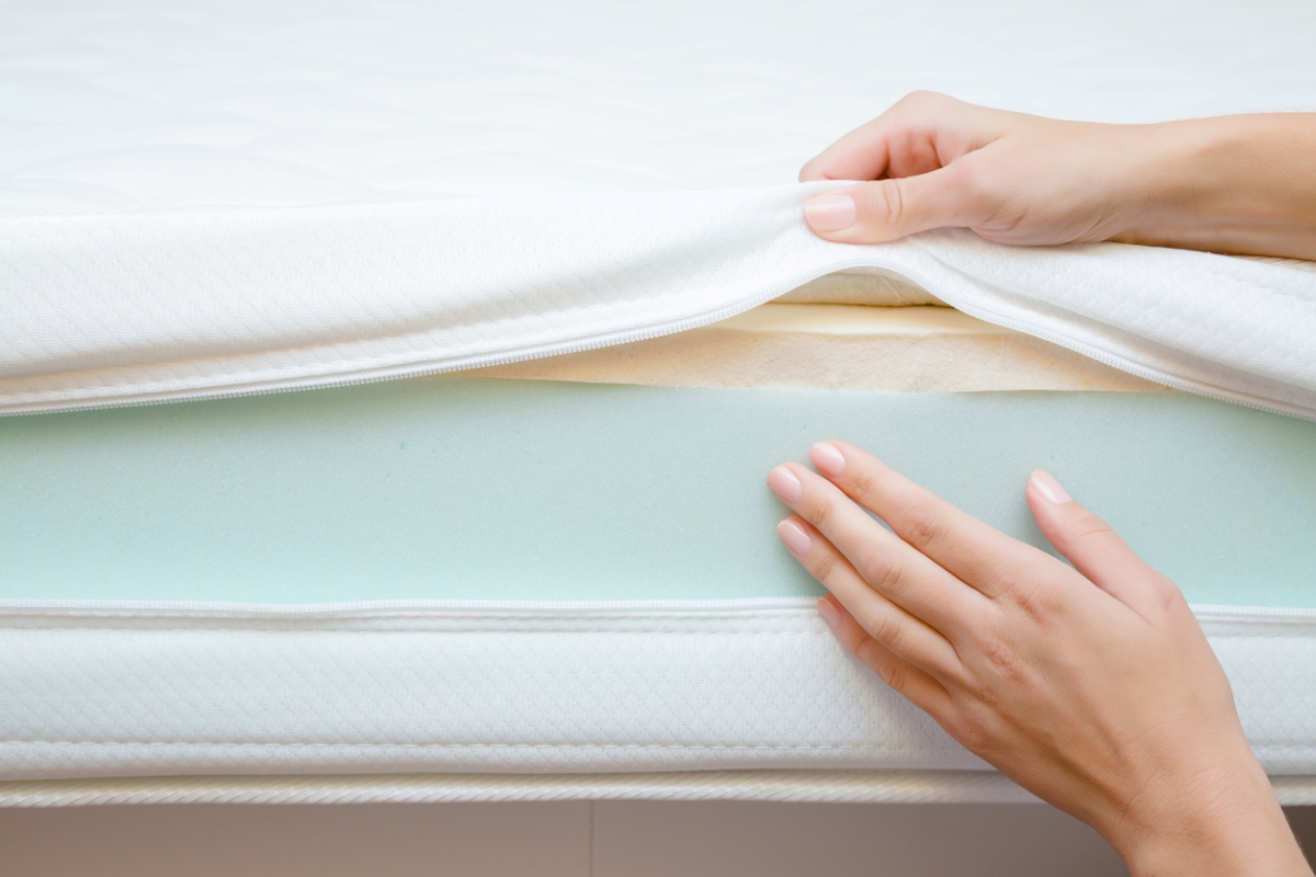 Person touching different layers of foam bed
