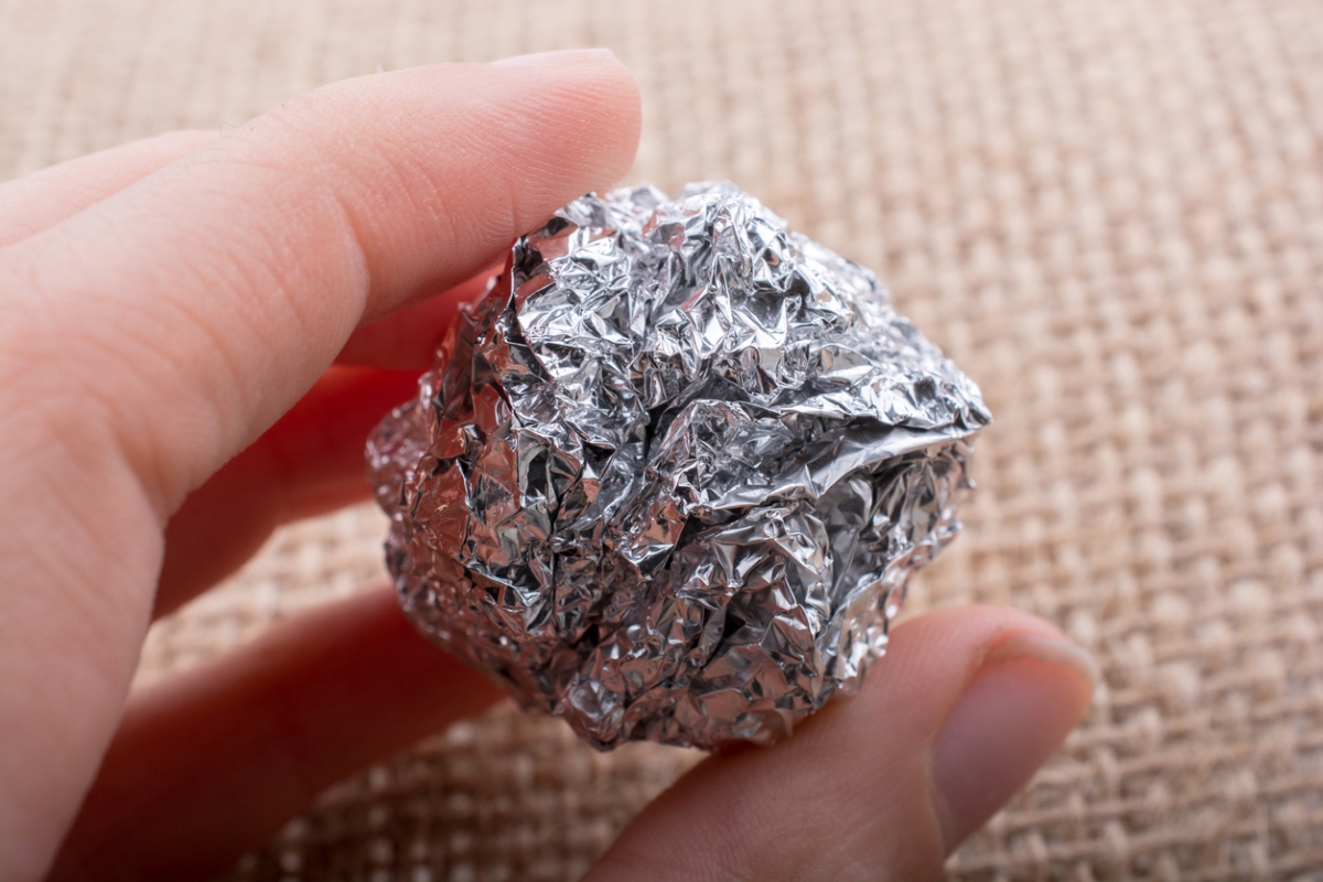 Person holding ball of aluminum foil