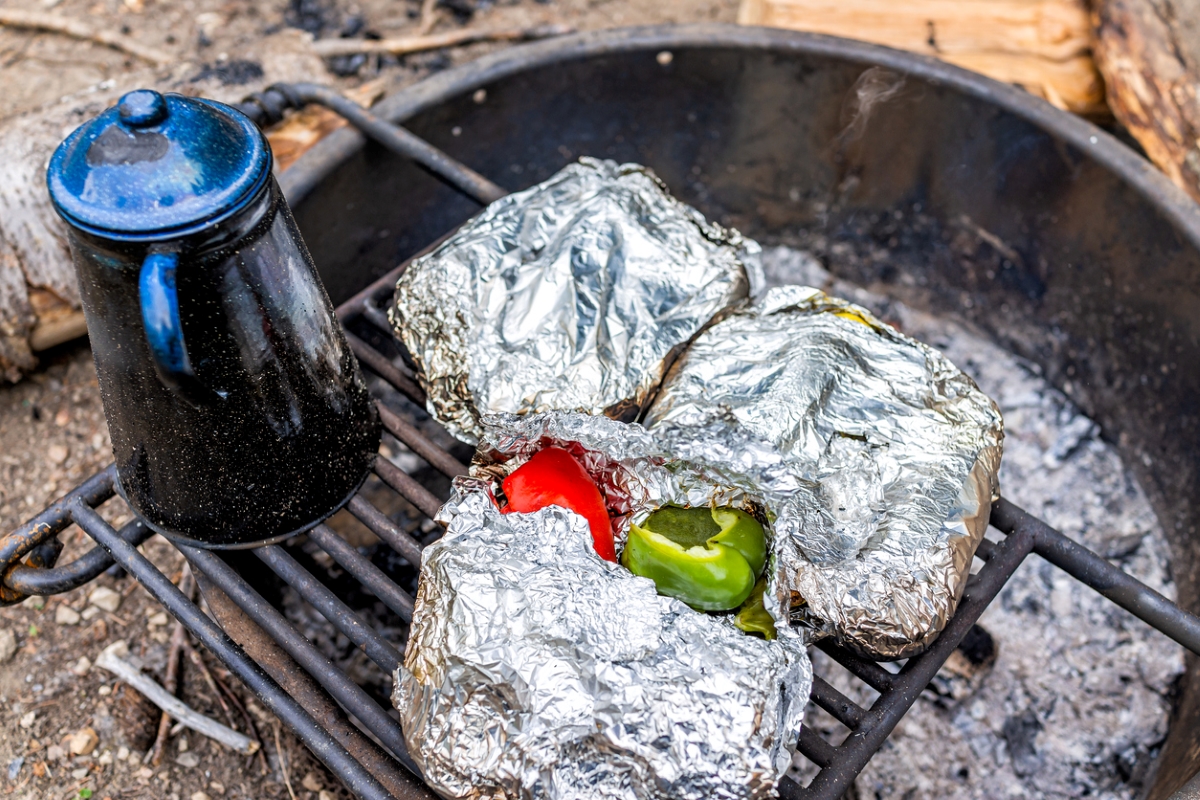 Aluminum foil covered food cooking in firepit