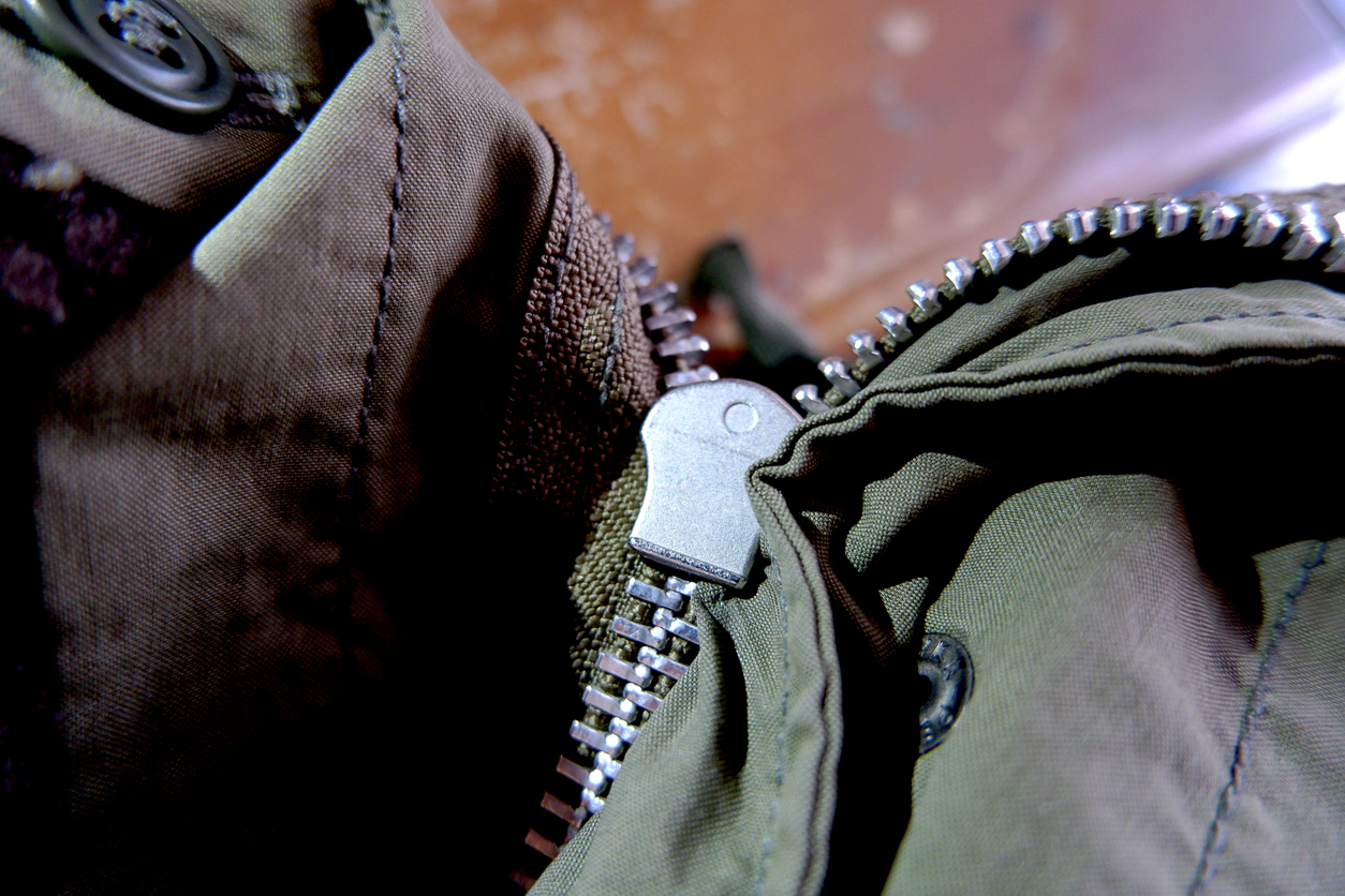 A close up of stuck zipper on a dark green jacket