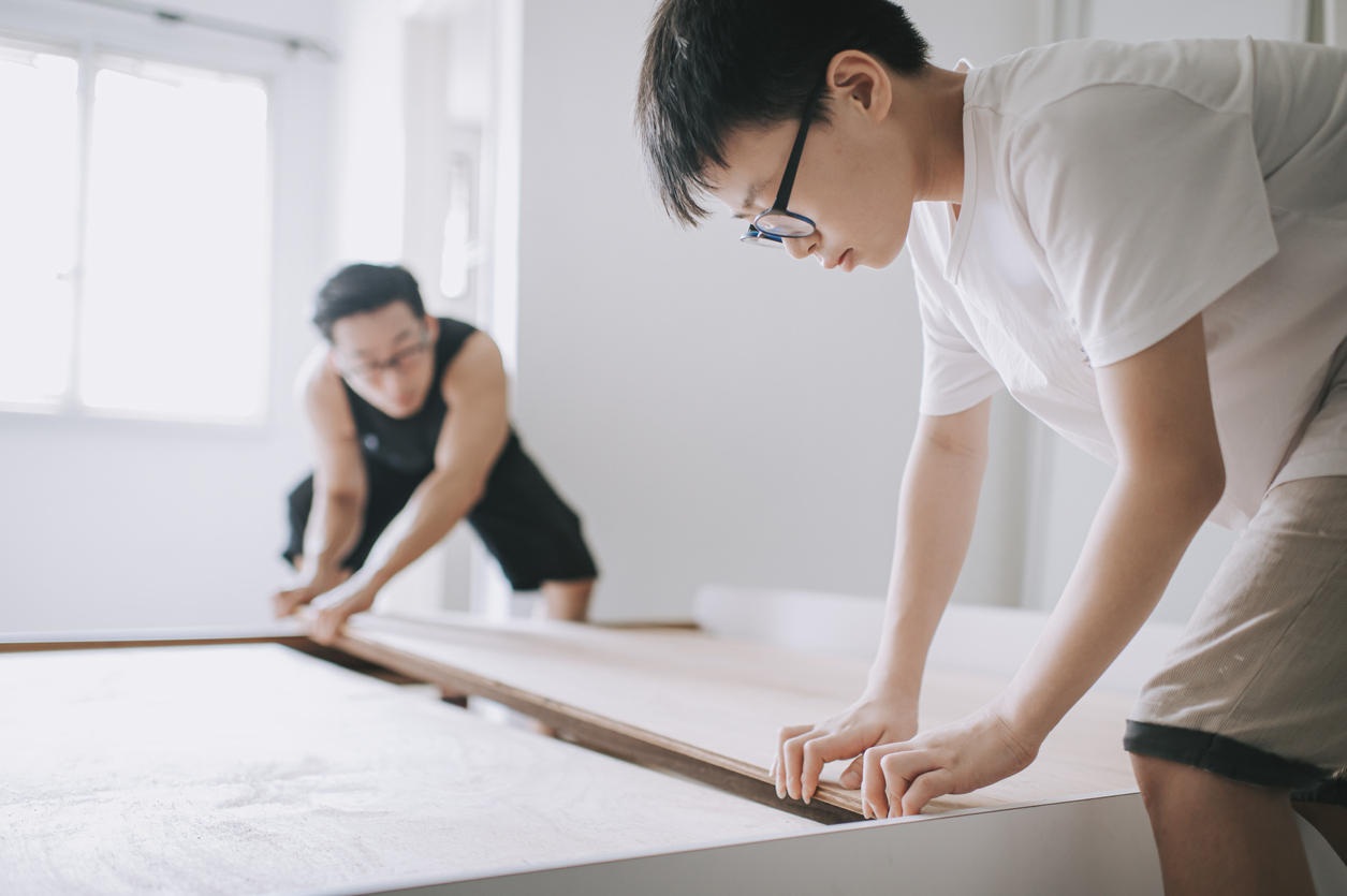 an asian chinese family moving house father and son assemble bed frame