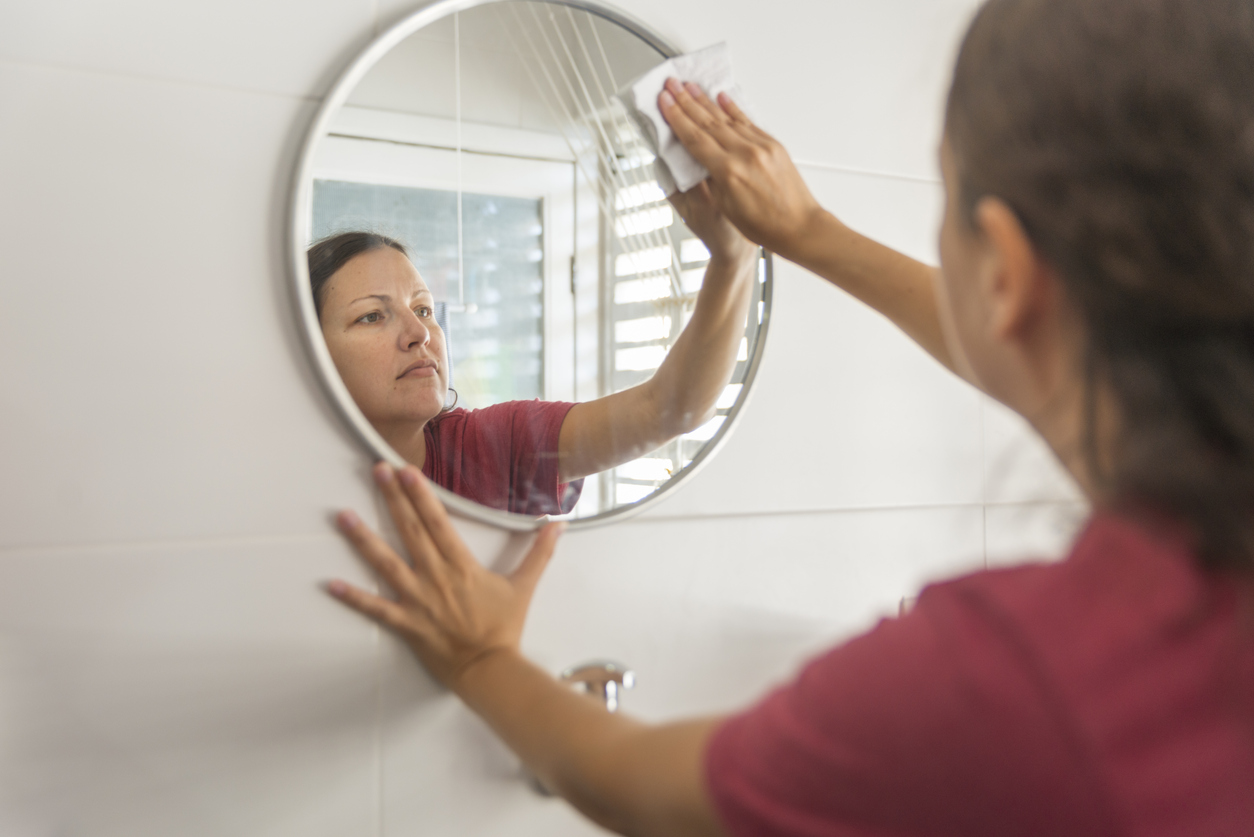 woman wiping mirror