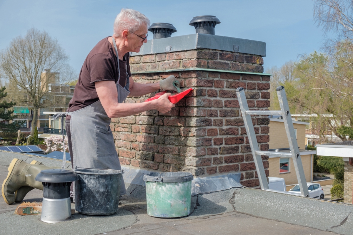 Man fixing exterior brick chimney