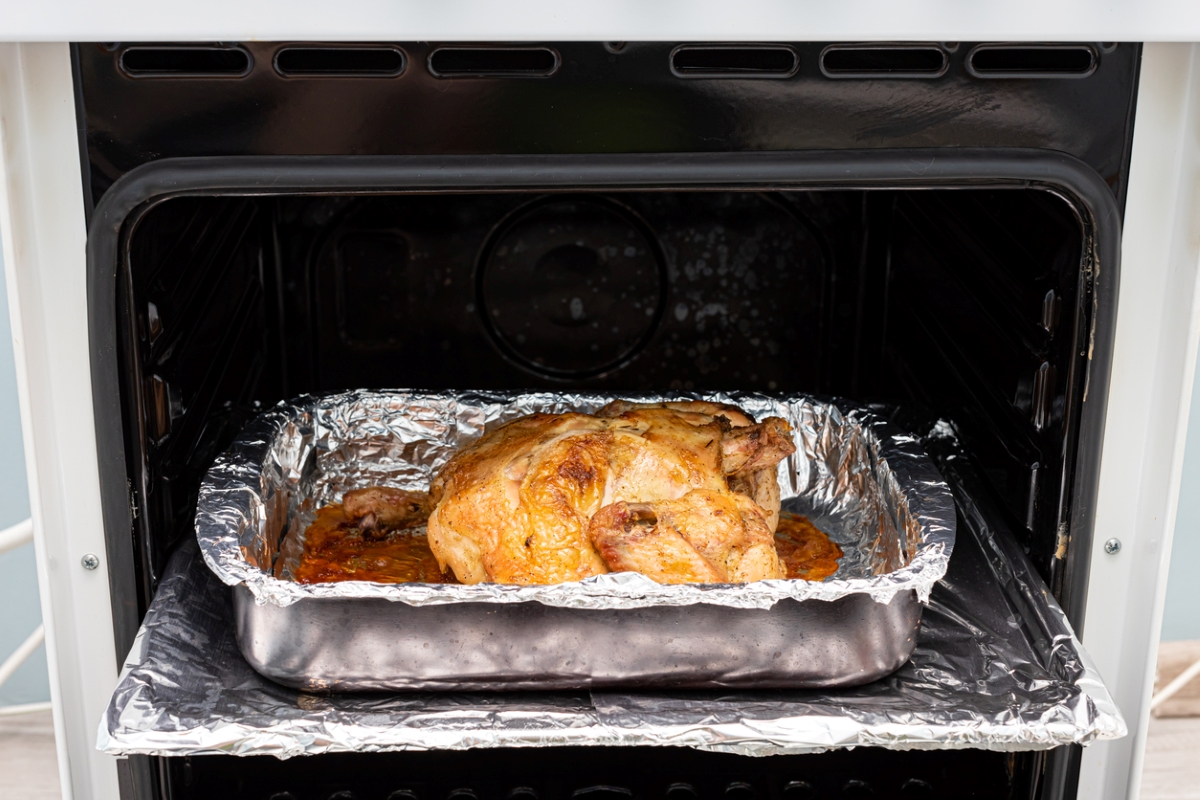 Aluminum foil lining oven rack under chicken dish