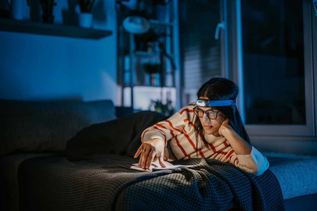 young-person-wears-a-headlamp-while-reading-during-a-power-outage