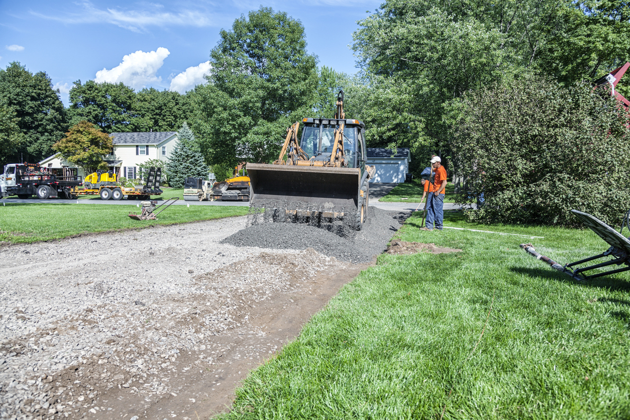 wide view of front loader grading residential path
