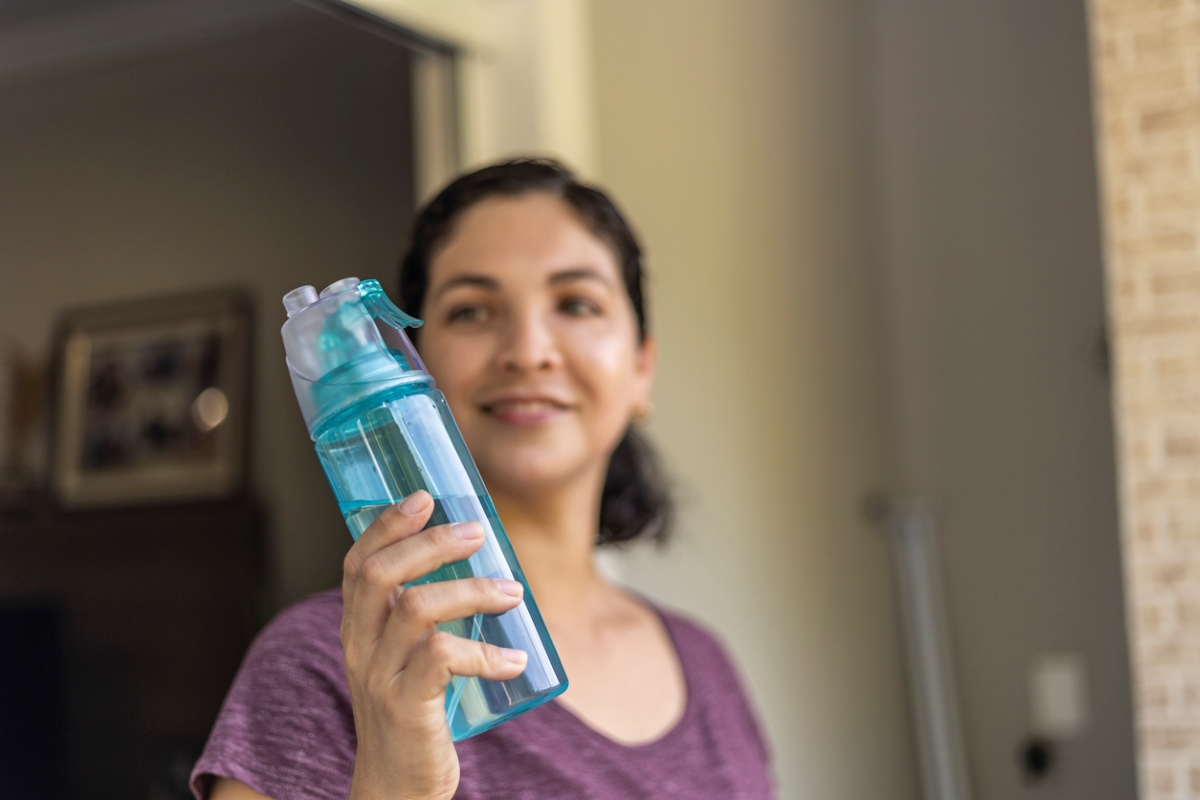 Woman holding reusable plastic bottle