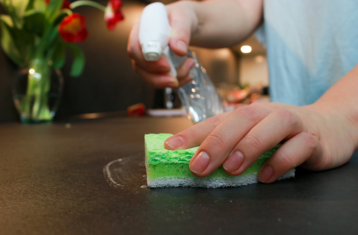 Using sponge to clean counter