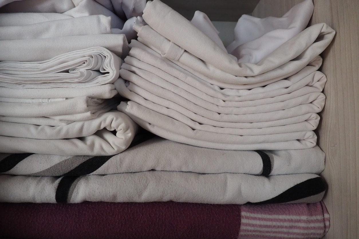 stack of bed linen in closet