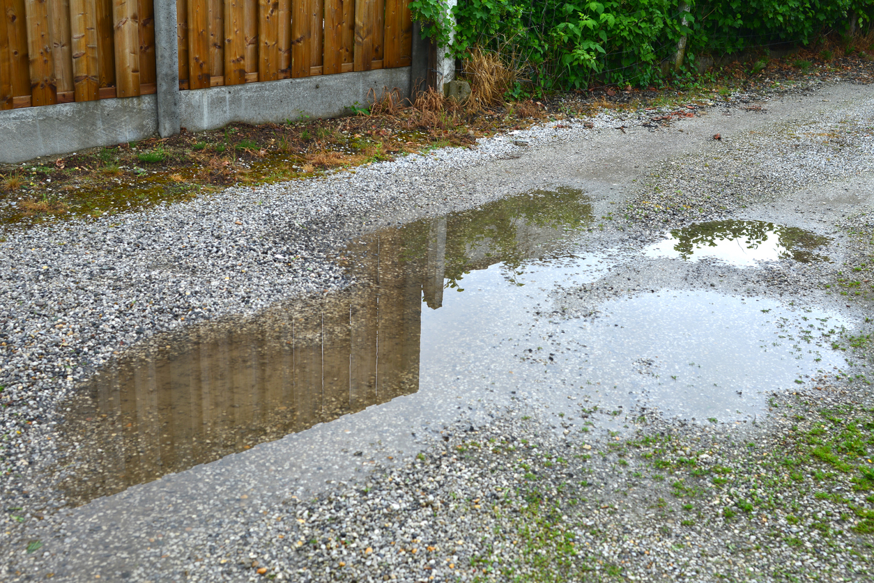 large puddle in gravel driveway