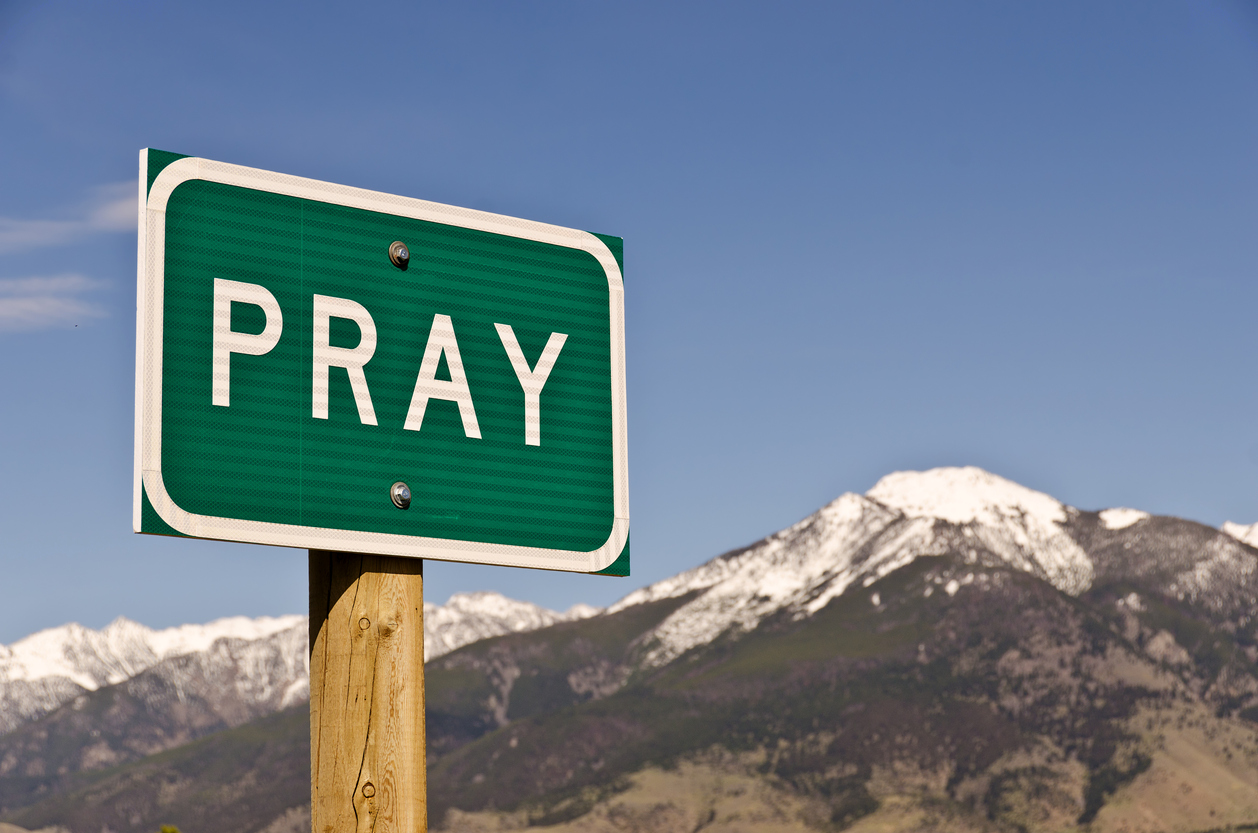 road sign for Pray, Montana in front of mountain