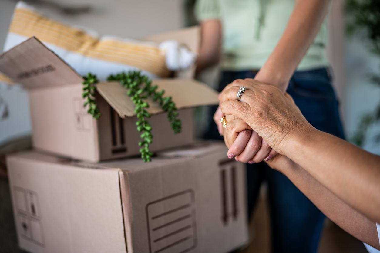 Mother and daughter holding hands on a moving house concept image