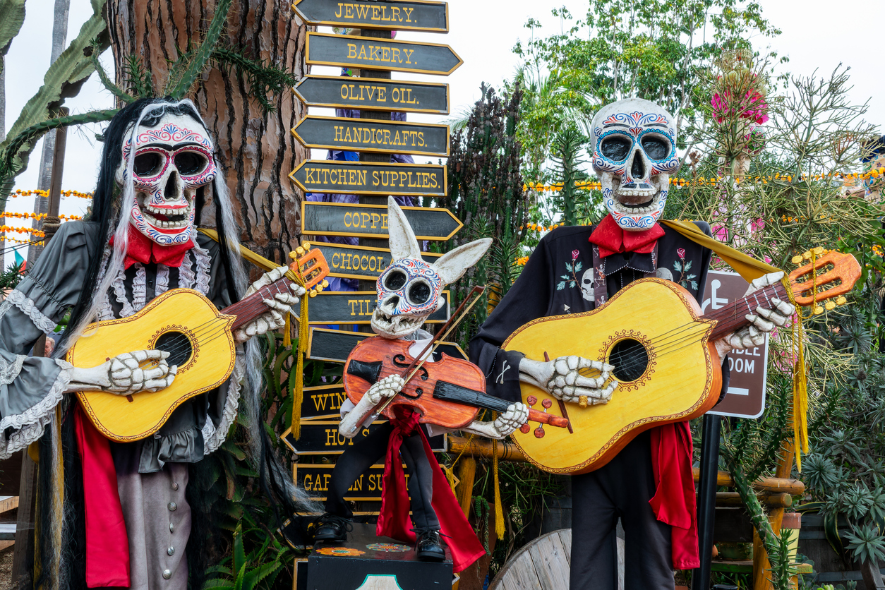 Dia de los Muertos (Day of the Dead) skeletons and sugar skulls, funny catrinas musicians playing guitar, Halloween decor in Old Town San Diego, California