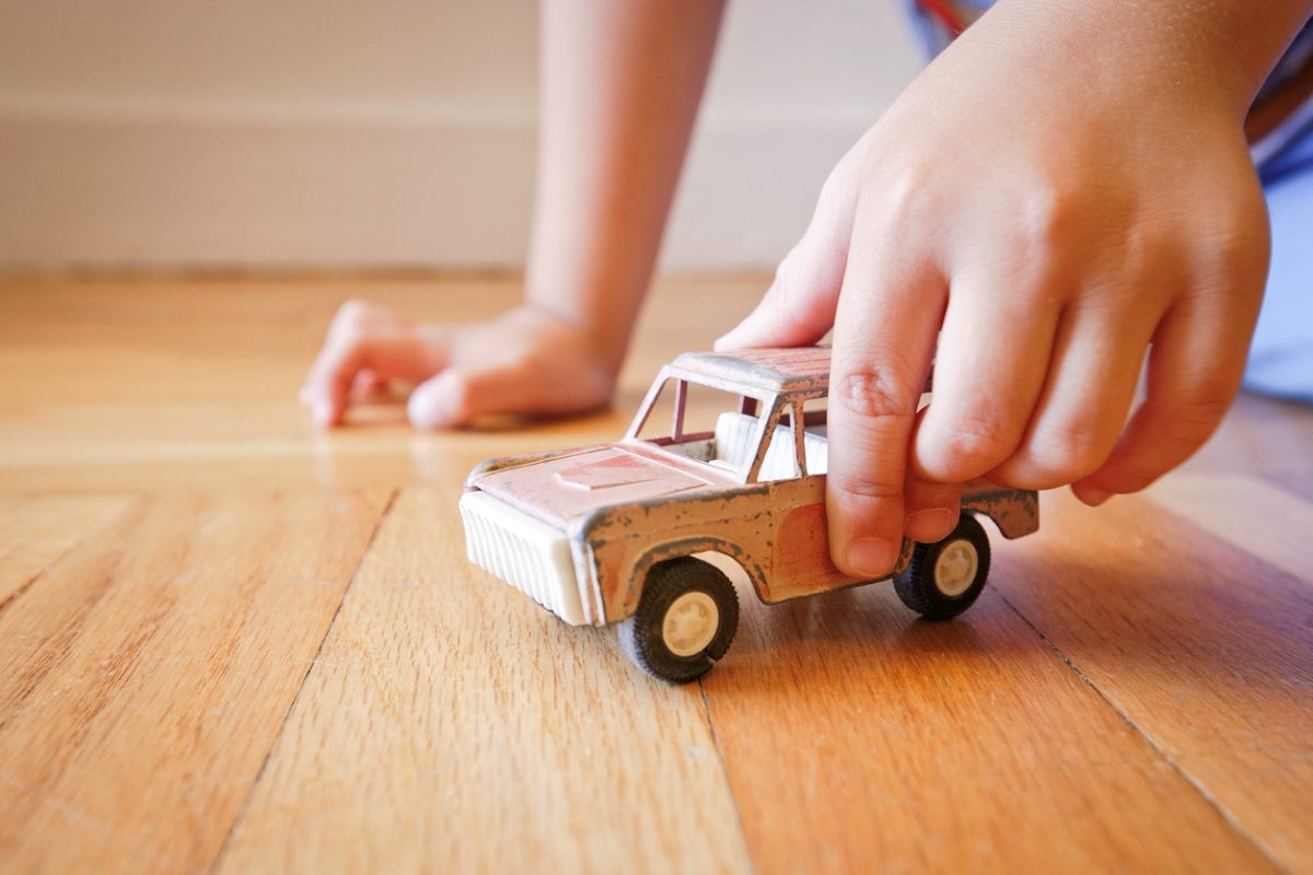 Child playing with metal toy car