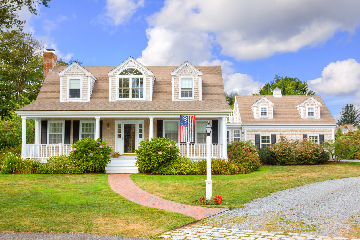 wide view of New England house with small American flag hanging out front