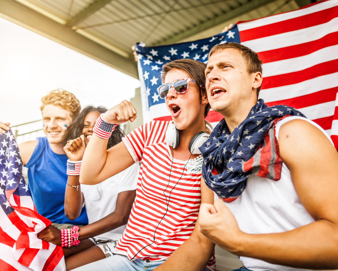group of friends wearing American flag themed clothing in front of American flag