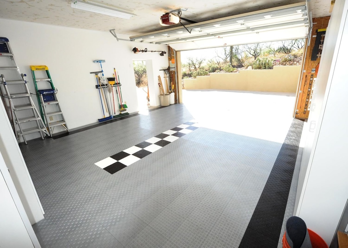 Checkered and grey interlocking tiles in a garage. 