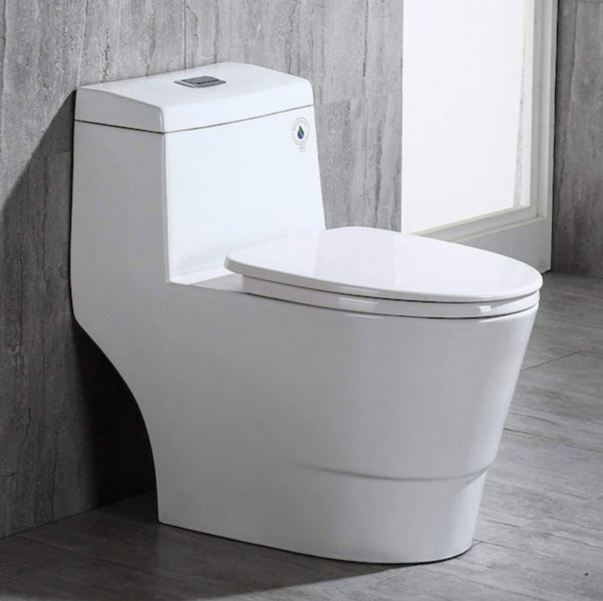 A grey bathroom has a WOODBRIDGE Bristol 1-piece 1.6-GPF high-efficiency elongated all-in-one toilet with soft-close seat.