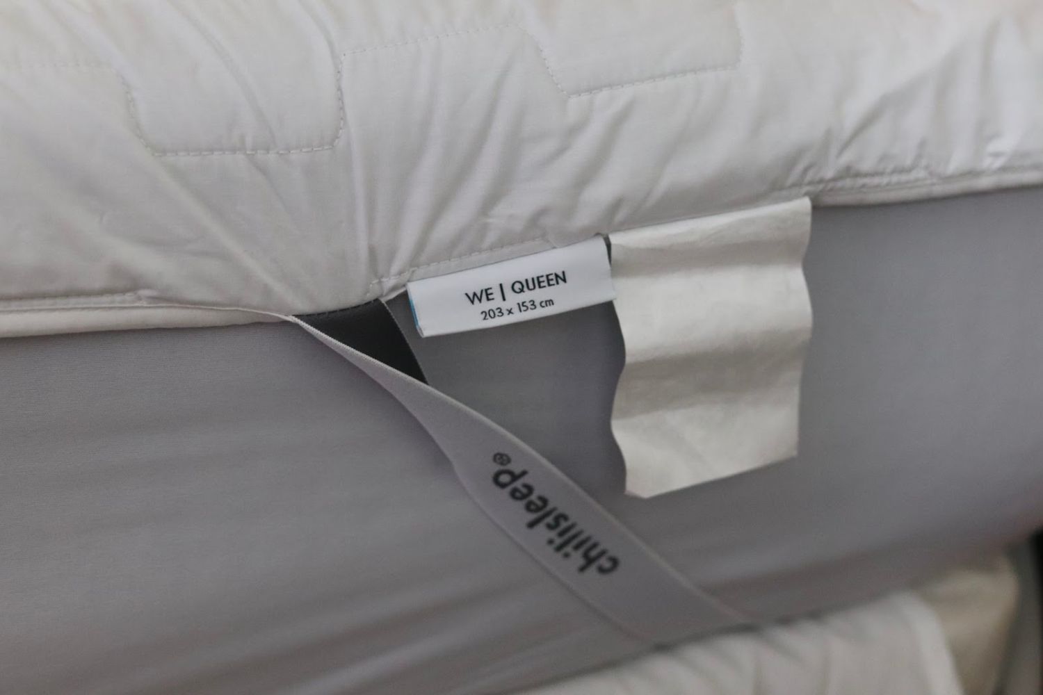 The elastic straps of the Chilipad Sleep System looped around a mattress and holding the system in place.