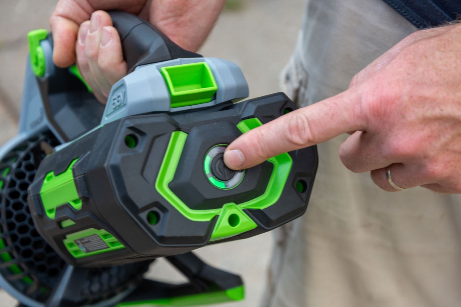 A person pressing the on/off button on the Ego Power+ 650 CFM 56V Leaf Blower.