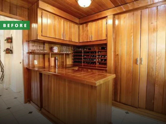 A retro wet bar completely covered with wood paneling in a before renovation state.