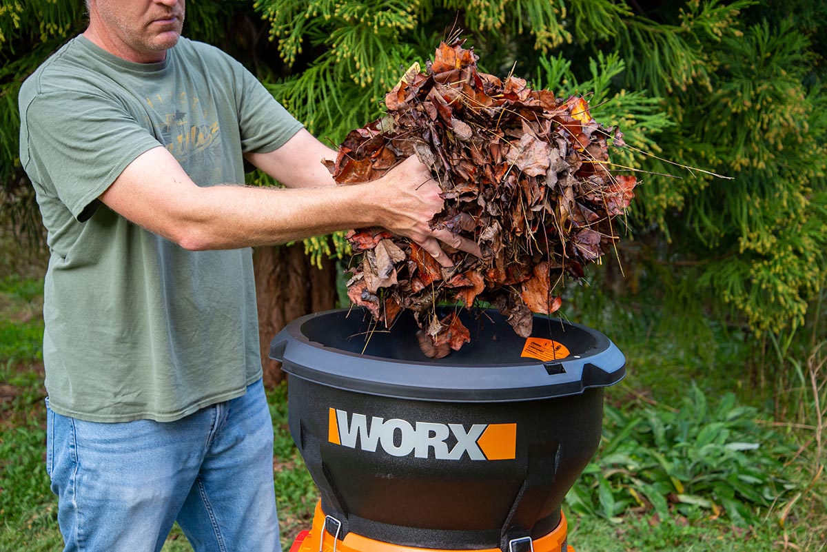 A man placing leaves into the Worx leaf mulcher