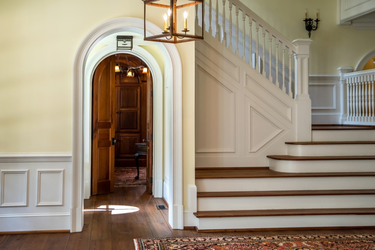 hallway in large house with view of staircase and doorway into other rooms