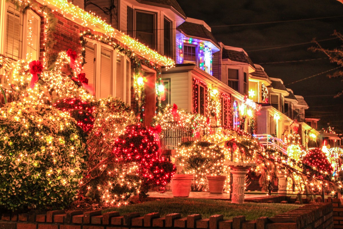 A row of houses decorated with bright colored christmas lights.
