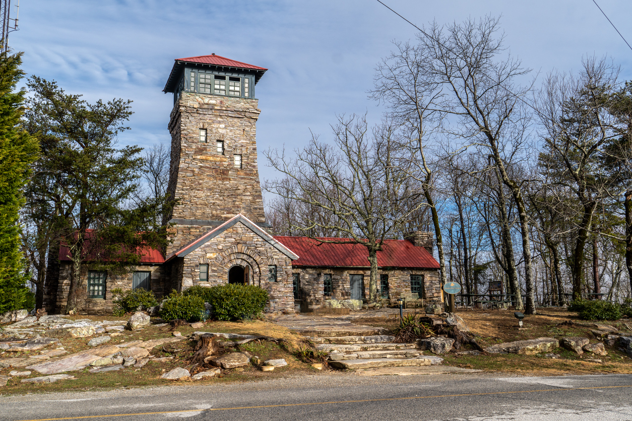 A stone building with a high tower built as a fire lookout with red roof and glass grid windows, round arch door, State high point, Bunker Tower, Cheaha State Park, Alabama