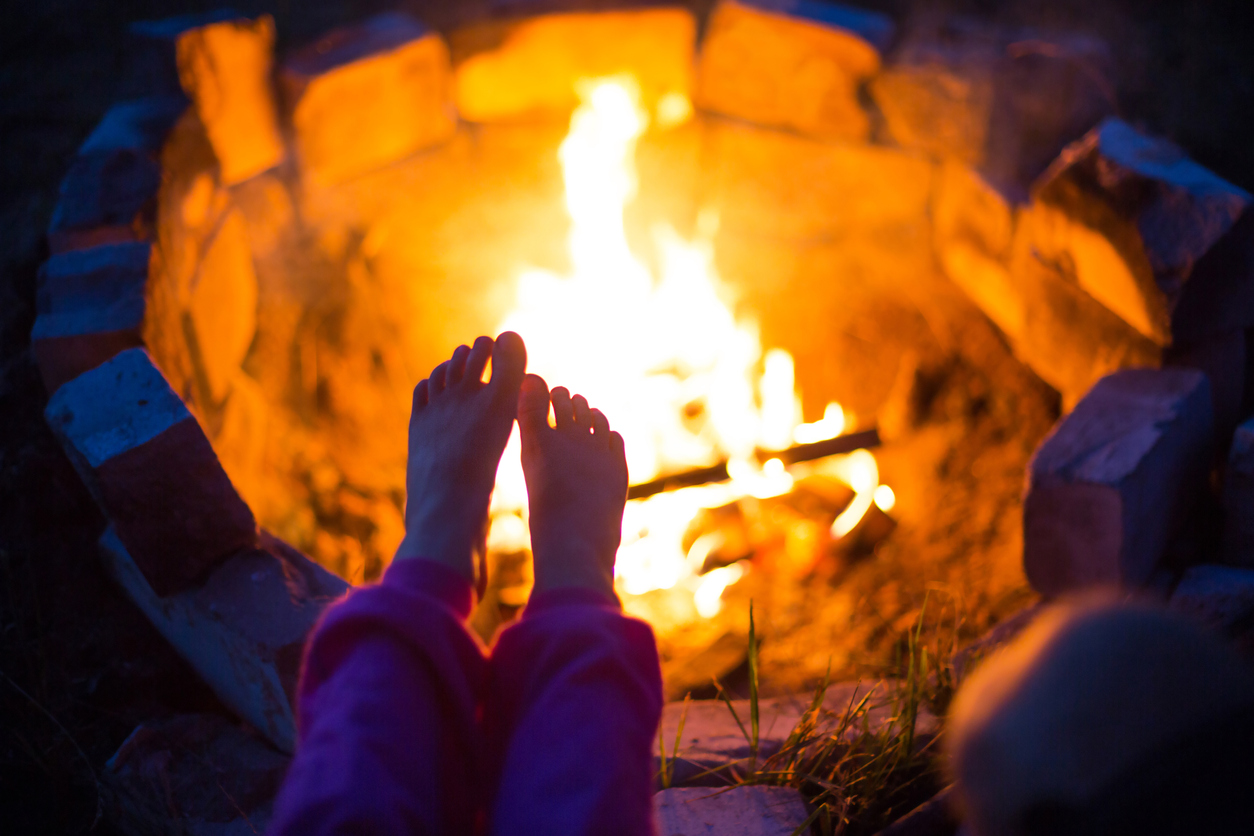 view of child's feet in front of bonfire
