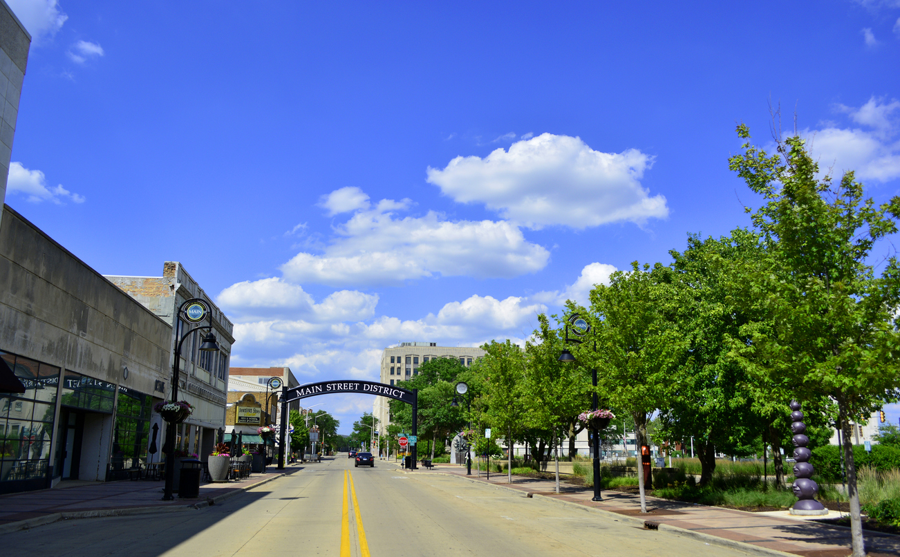 main street with large trees and blue sky in Rockford, Illinois