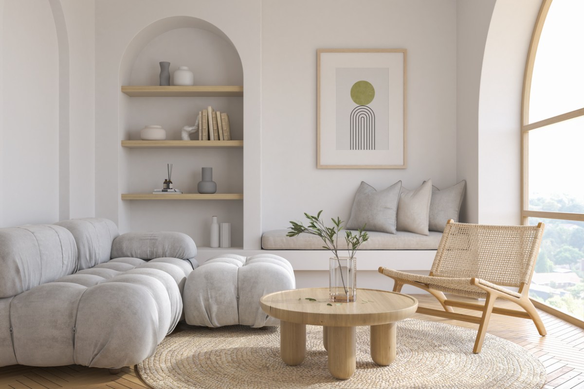 A light colored living room decorated in the japandi style of minimal furniture and color palette