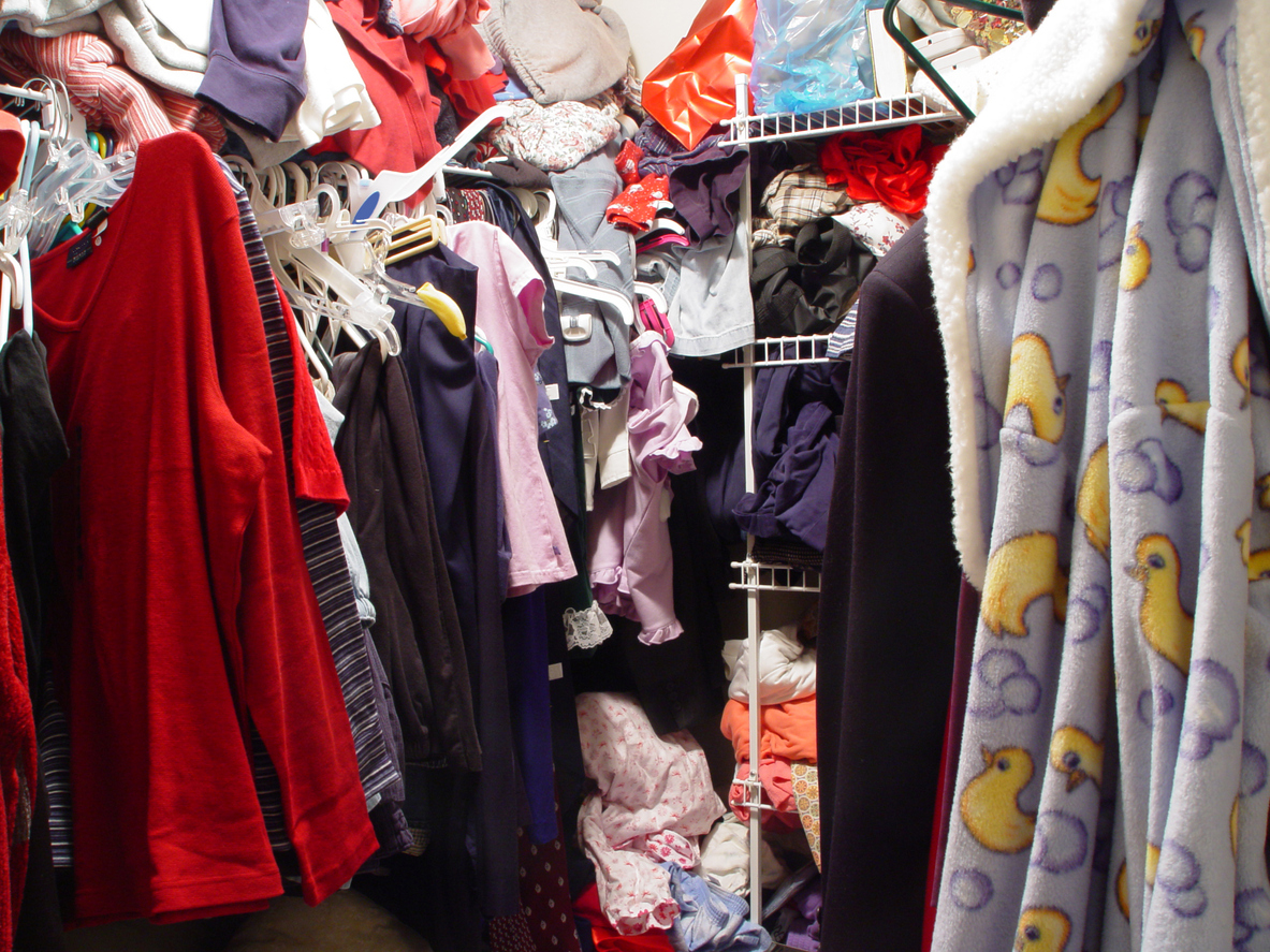 "Clothes on hangers, shelves, and just stuffed into any available space"