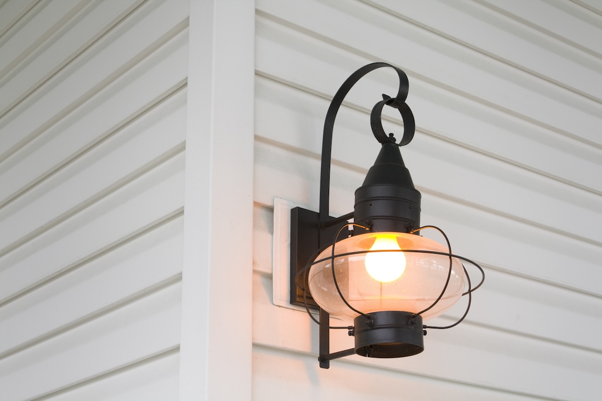 Bright yellow led porch light mounted on the side of a house.