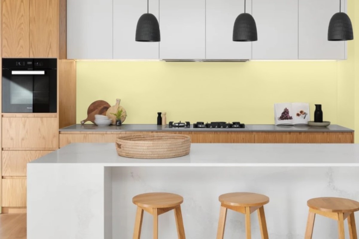 Kitchen with white island and yellow wall.
