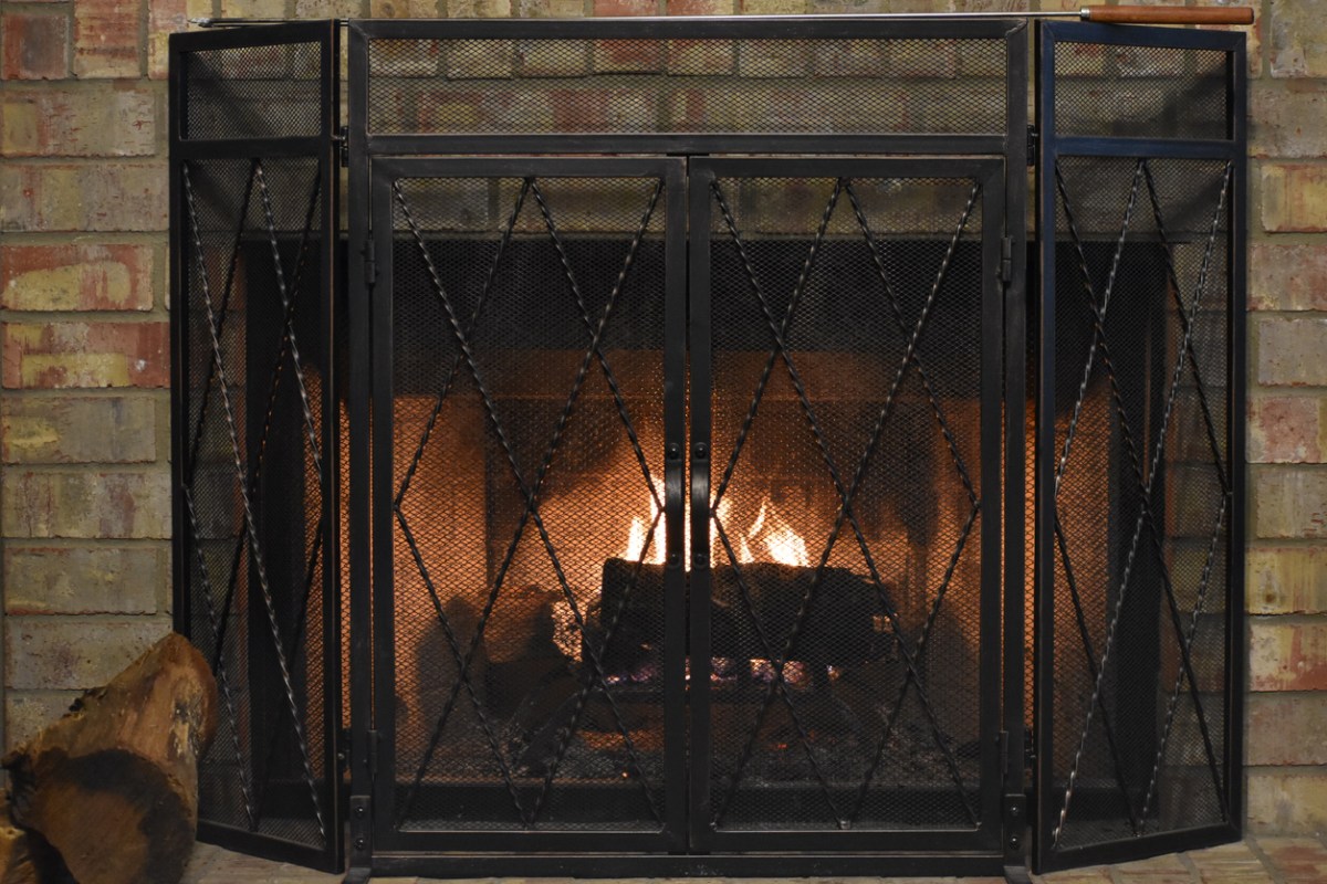 The best fireplace screen protecting a brick surround from a burning fire.