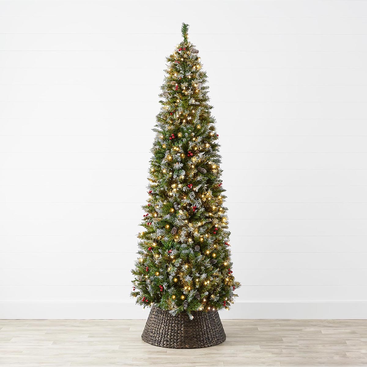 The Best Choice Products Spruce w/ Berries, Pine Cones in a dark wicker basket on a wood floor in front of a white wall.